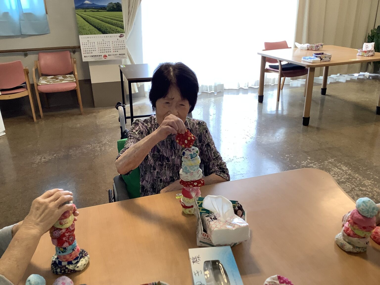 入居者がクラフト活動でお菓子の塔を作る様子。共用スペースでのレクリエーション。