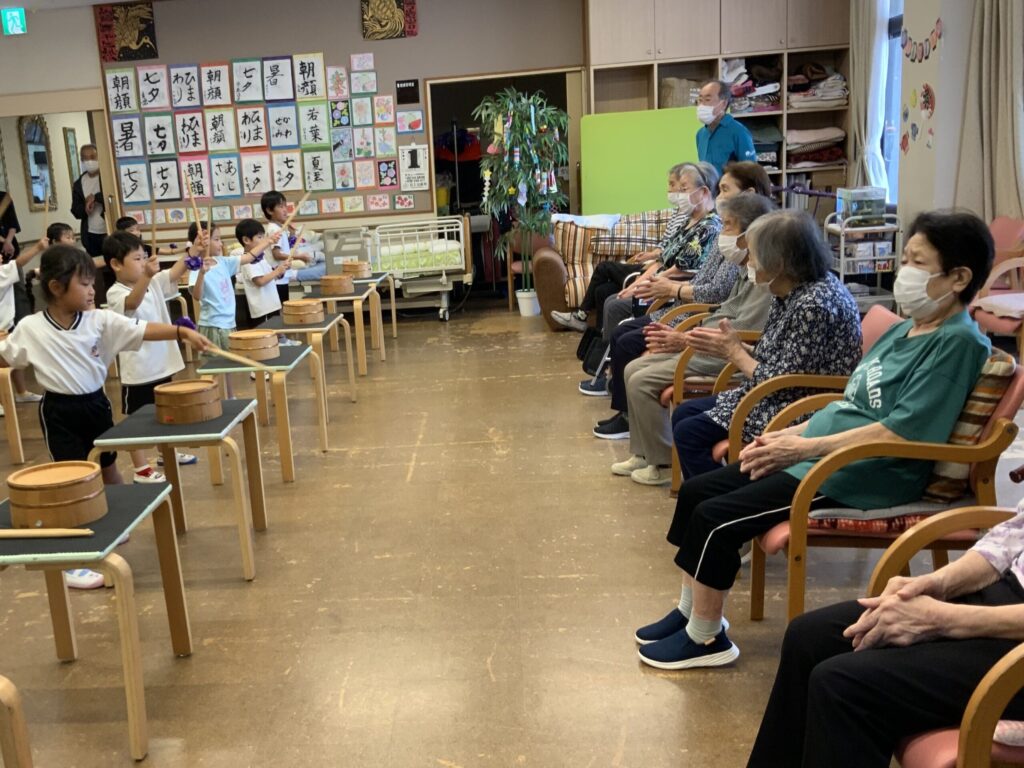 子どもたちと高齢者による交流イベント。太鼓演奏や音楽活動の世代間交流の様子。